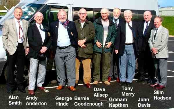 Nine men standing in a line.