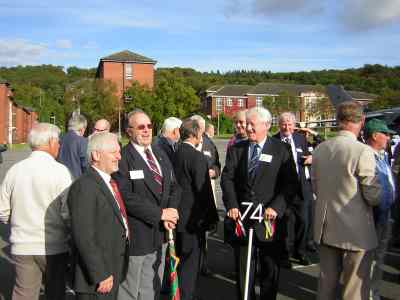 Men standing in a group on a barrack square.
