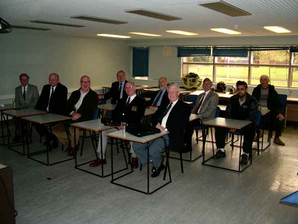 Back to school for the lads. Group of men sat at desks in an office.