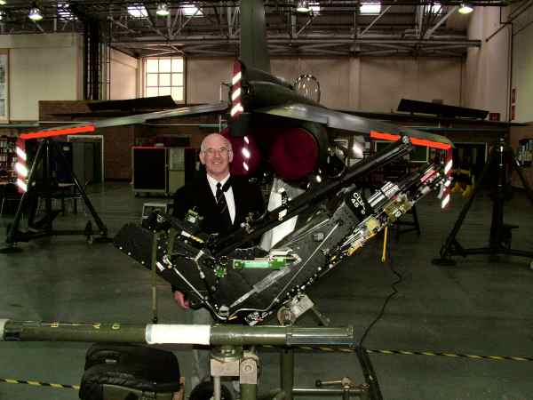 Man standing behind an  aircraft ejector seat.