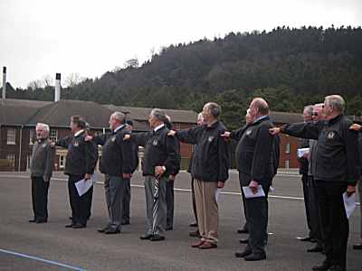 A group of seventy year olds on a parade ground performing a right dress drill movement.